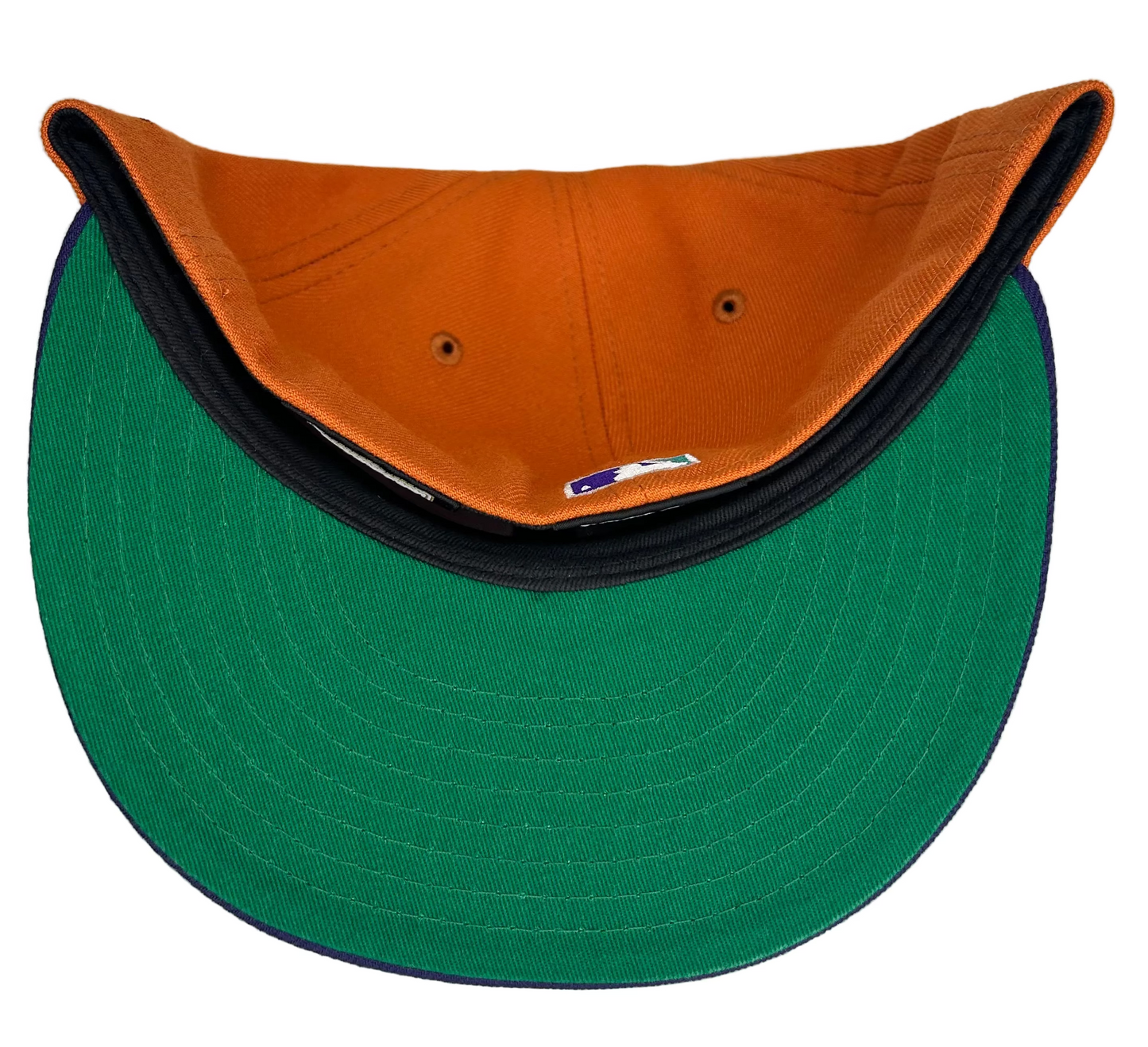 New Era Cactus Fruit Oakland Athletics 50th Anniversary Patch Stomper Hat features a burnt orange crown, a purple brim, a green under-visor, and a 50th-anniversary patch.