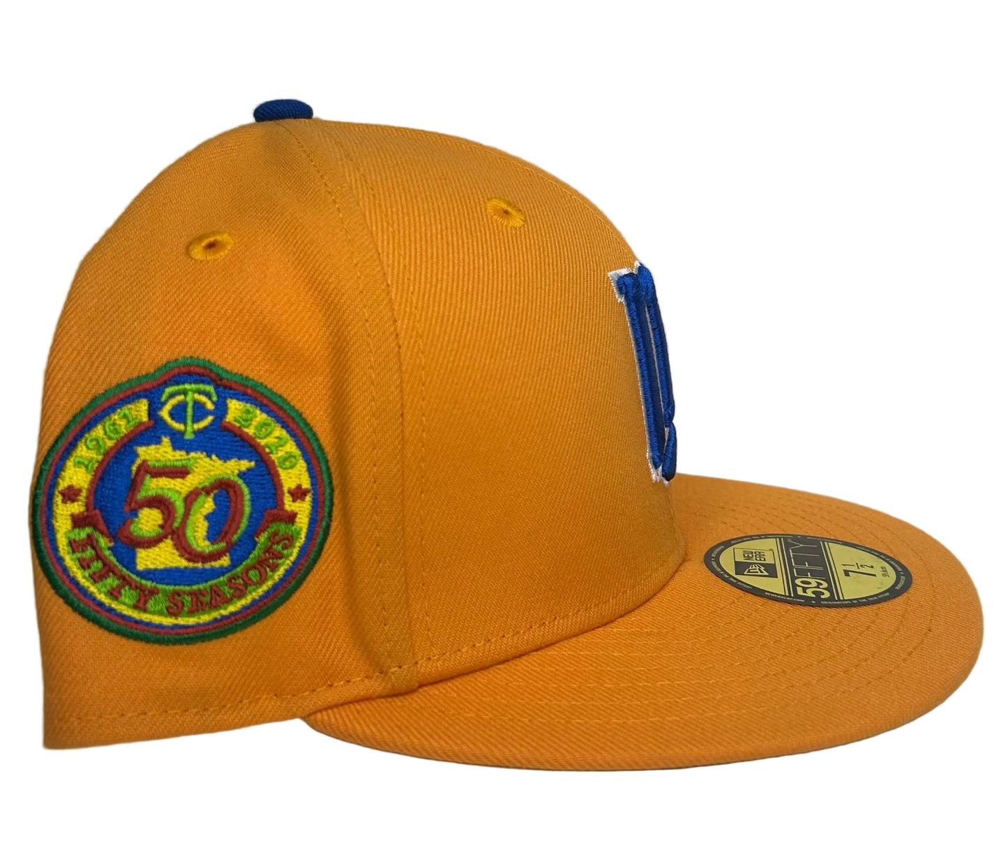 New Era 59FIFTY Minnesota Twins fitted hat features a vibrant orange and yellow colorway with a bold blue "M" logo and a commemorative side patch.