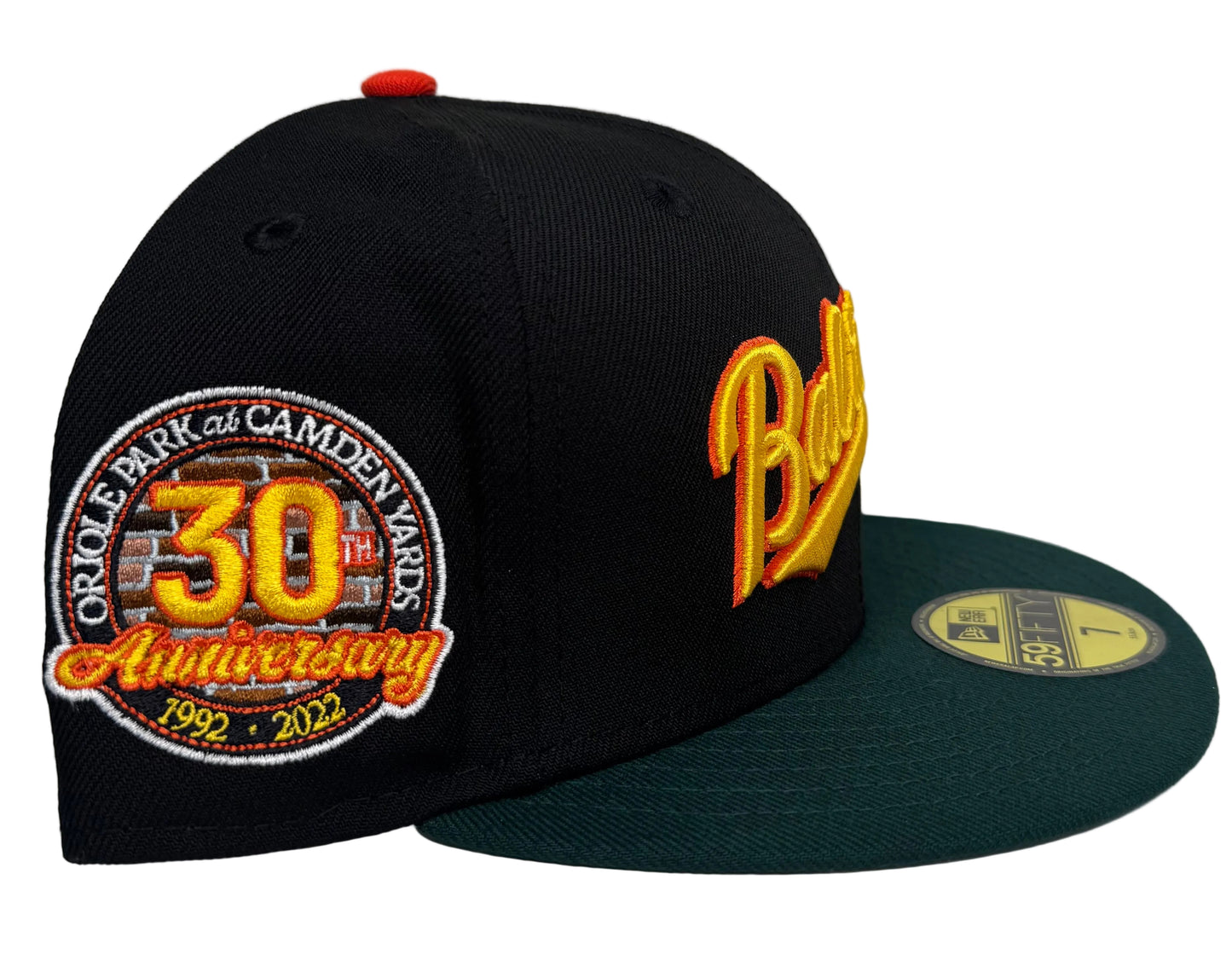 New Era Baltimore Orioles 30th Anniversary Community Edition 59FIFTY fitted cap features a black crown, dark green brim, and a retro "Baltimore" script embroidery.