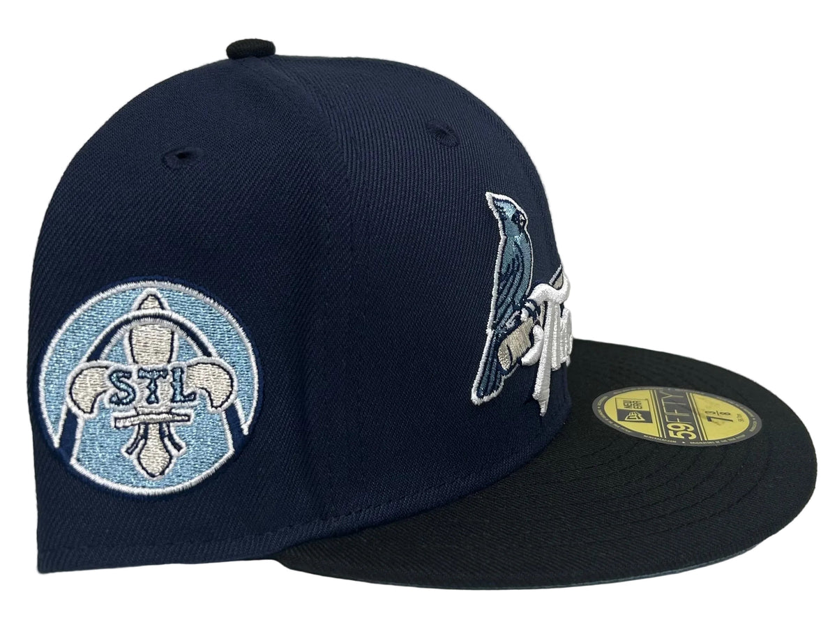 New Era 59Fifty St. Louis Cardinals "The Lou" fitted hat features a navy blue crown with light blue embroidery and a matching city patch.