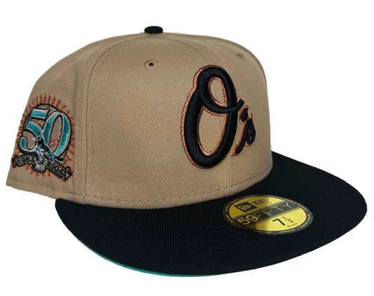 New Era Baltimore Orioles 59FIFTY fitted hat features a beige crown, black visor, and a 50th-anniversary patch on the side.