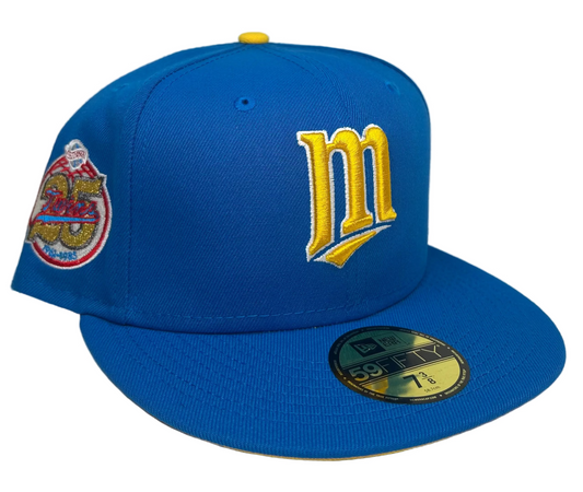 New Era Minnesota Twins Maggie Simpson Pack 59FIFTY fitted hat featuring a bright blue crown and a yellow interlocking 'M' logo inspired by The Simpsons.