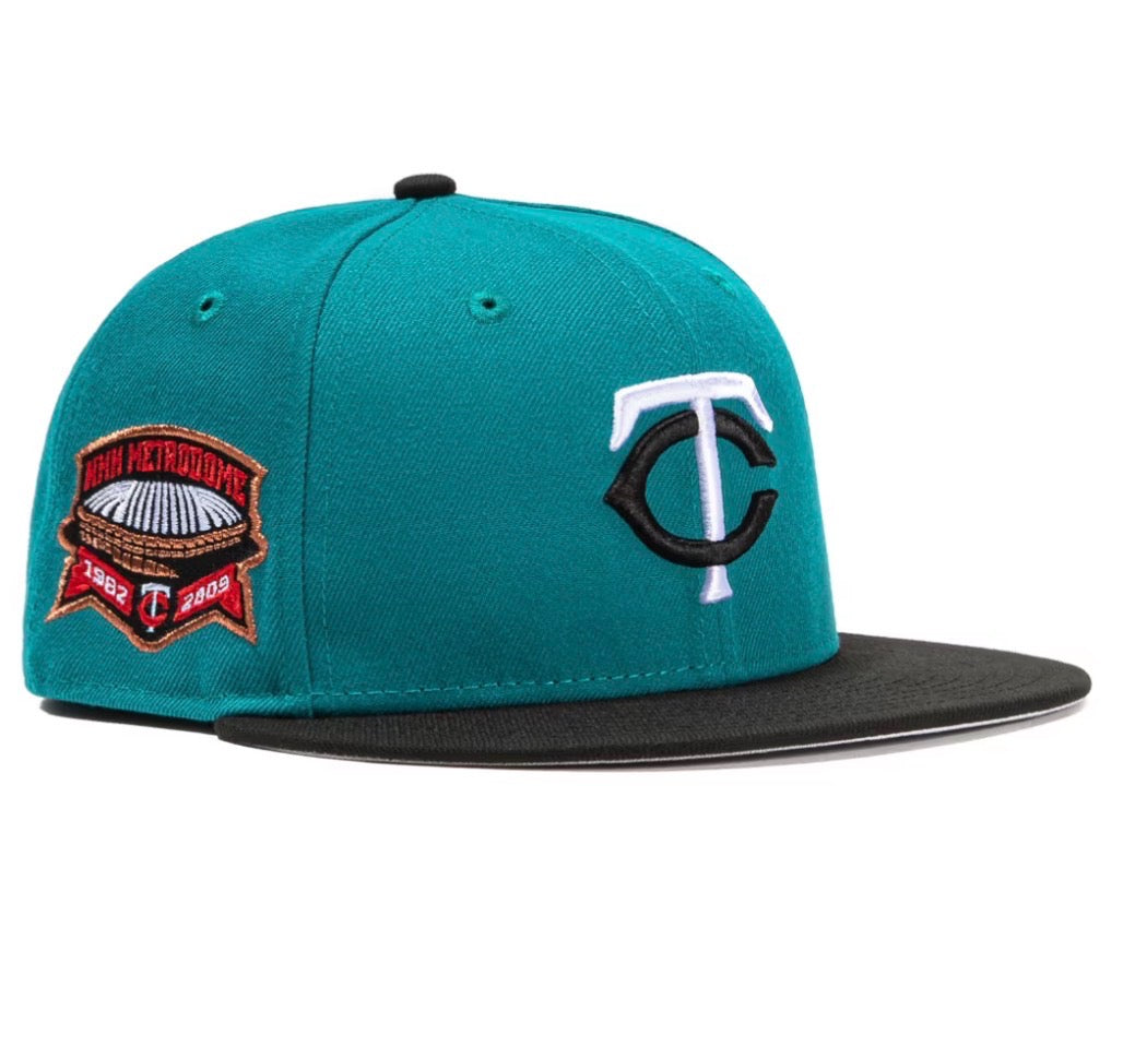 Minnesota Twins Quiet Storm Metrodome Stadium Patch 59Fifty fitted hat in the navy and teal colorway. The hat features a teal crown and a black brim with a patch on the side commemorating the Metrodome from 1982-2009. 