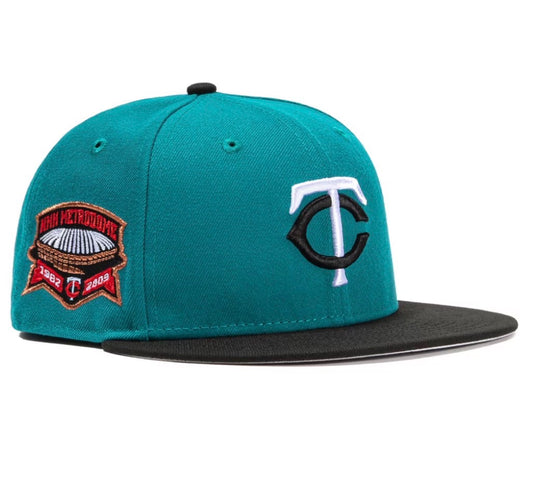 Minnesota Twins Quiet Storm Metrodome Stadium Patch 59Fifty fitted hat in the navy and teal colorway. The hat features a teal crown and a black brim with a patch on the side commemorating the Metrodome from 1982-2009. 