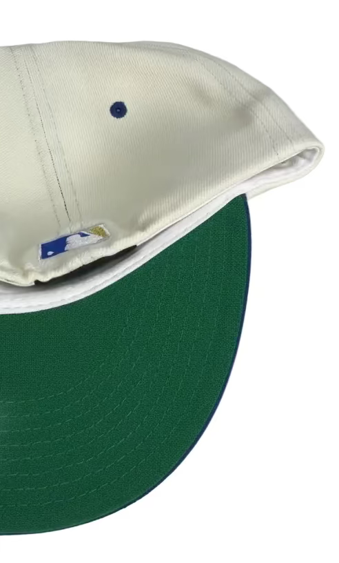 New Era Kansas City Royals 59FIFTY fitted cap features an off-white crown, royal blue visor, and a gold embroidered "R" logo with a crown on top.