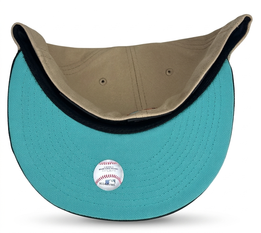 New Era Baltimore Orioles 59FIFTY fitted hat features a beige crown, black visor, and a 50th-anniversary patch on the side.