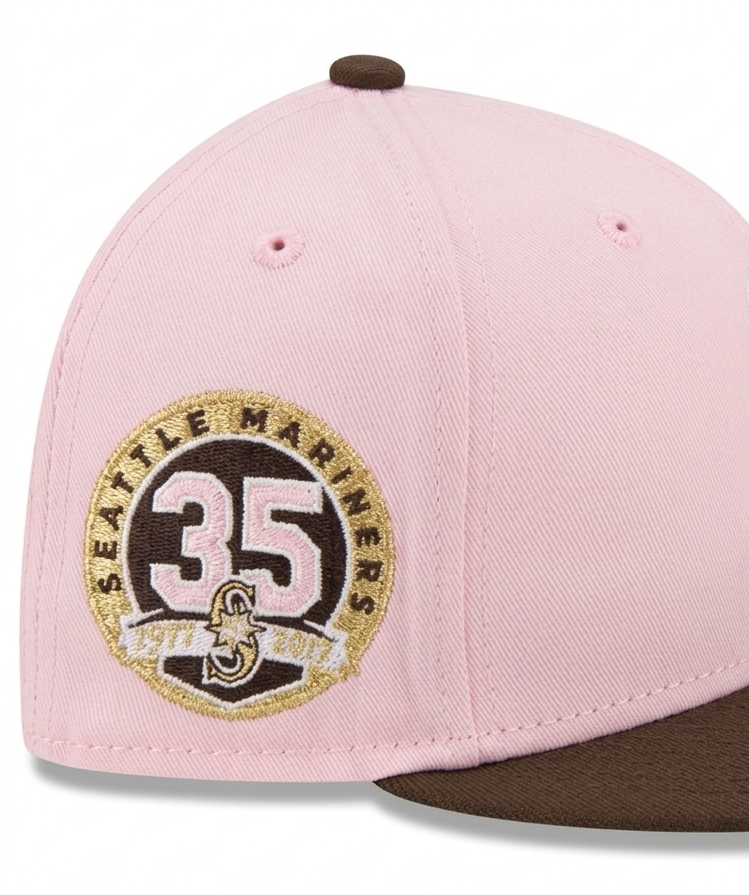 New Era 59Fifty Seattle Mariners fitted hat features a distinctive pink crown with a chocolate brown brim and a 35th Anniversary patch on the side.